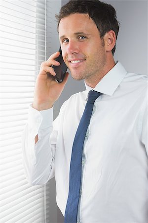 simsearch:400-07141019,k - Smiling handsome businessman phoning in room Stockbilder - Microstock & Abonnement, Bildnummer: 400-07139155