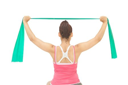 simsearch:400-07139290,k - Sporty brunette stretching with resistance band on white background Stock Photo - Budget Royalty-Free & Subscription, Code: 400-07139216