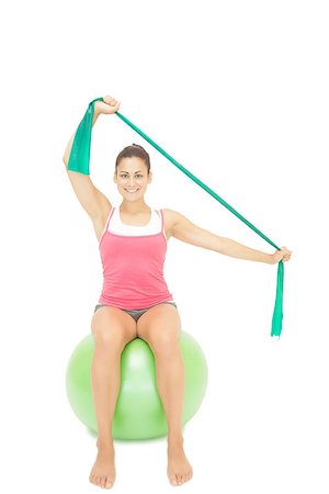 simsearch:400-07139290,k - Gleeful sporty brunette stretching with resistance band on white background Stock Photo - Budget Royalty-Free & Subscription, Code: 400-07139224