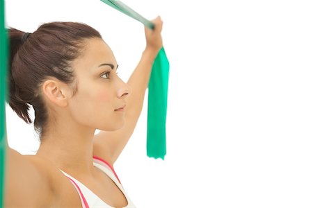 simsearch:400-07139290,k - Serious sporty brunette stretching with resistance band on white background Stock Photo - Budget Royalty-Free & Subscription, Code: 400-07139222
