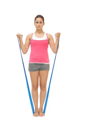 simsearch:400-07139290,k - Stern sporty brunette exercising with resistance band on white background Stock Photo - Budget Royalty-Free & Subscription, Code: 400-07139234