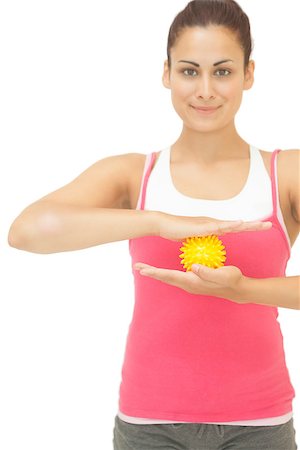 simsearch:400-07139290,k - Smiling sporty brunette holding yellow massage ball on white background Stock Photo - Budget Royalty-Free & Subscription, Code: 400-07139237