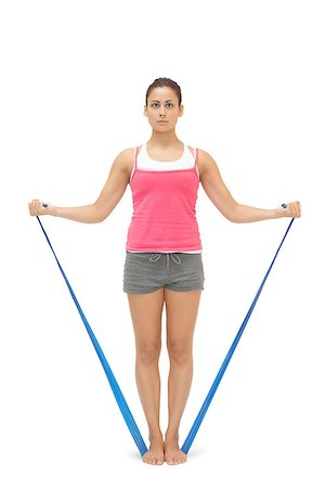 simsearch:400-07139290,k - Serious sporty brunette exercising with resistance band on white background Stock Photo - Budget Royalty-Free & Subscription, Code: 400-07139233