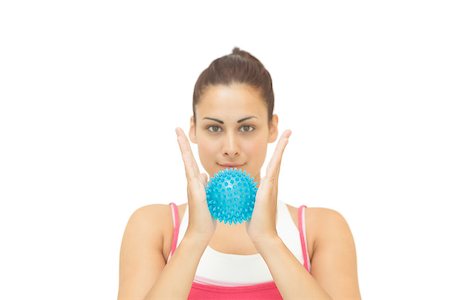 simsearch:400-07139290,k - Content sporty brunette holding blue massage ball between hands on white background Stock Photo - Budget Royalty-Free & Subscription, Code: 400-07139244