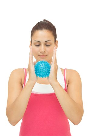 simsearch:400-07139290,k - Smiling sporty brunette holding blue massage ball between hands on white background Stock Photo - Budget Royalty-Free & Subscription, Code: 400-07139245