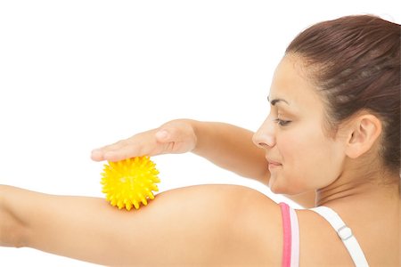 simsearch:400-07139290,k - Calm sporty brunette touching arm with yellow massage ball on white background Stock Photo - Budget Royalty-Free & Subscription, Code: 400-07139243