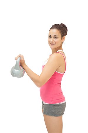 simsearch:400-07139290,k - Pretty sporty brunette holding grey and pink kettlebell on white background Stock Photo - Budget Royalty-Free & Subscription, Code: 400-07139258