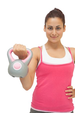 simsearch:400-07139290,k - Smiling sporty brunette holding grey and pink kettlebell on white background Stock Photo - Budget Royalty-Free & Subscription, Code: 400-07139252