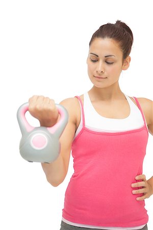 simsearch:400-07139290,k - Content sporty brunette holding grey and pink kettlebell on white background Stock Photo - Budget Royalty-Free & Subscription, Code: 400-07139253