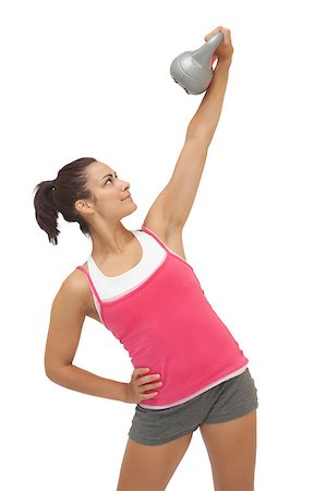simsearch:400-07139290,k - Happy sporty brunette holding grey and kettlebell on white background Stock Photo - Budget Royalty-Free & Subscription, Code: 400-07139262