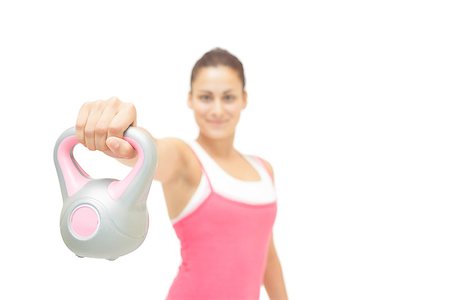 simsearch:400-07139290,k - Smiling toned brunette showing grey and pink kettlebell on white background Stock Photo - Budget Royalty-Free & Subscription, Code: 400-07139270