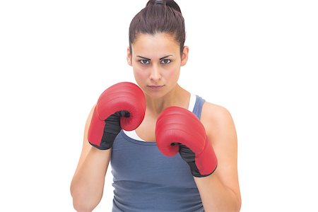 simsearch:400-07139290,k - Serious sporty brunette wearing red boxing gloves on white background Stock Photo - Budget Royalty-Free & Subscription, Code: 400-07139280