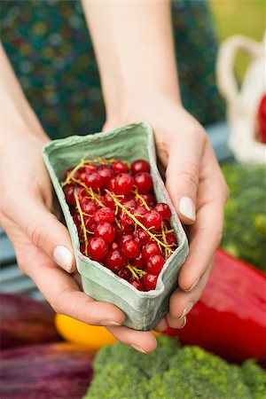 Hands holding carton of redcurrants with table of vegetables in background Stock Photo - Budget Royalty-Free & Subscription, Code: 400-07139602