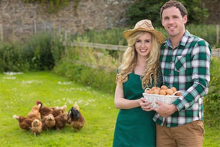 Young couple holding a basket filled with eggs in their garden with chickens behind Stock Photo - Budget Royalty-Free & Subscription, Code: 400-07139626