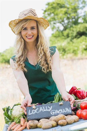 Smiling young female farmer standing at her stall in the farmers market while looking at the camera Stock Photo - Budget Royalty-Free & Subscription, Code: 400-07139623