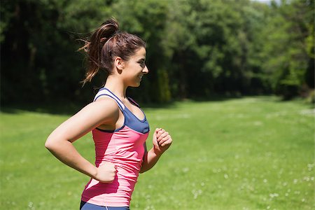 simsearch:400-07682342,k - Fit woman running in the sunshine and smiling outside in a park Stock Photo - Budget Royalty-Free & Subscription, Code: 400-07139838