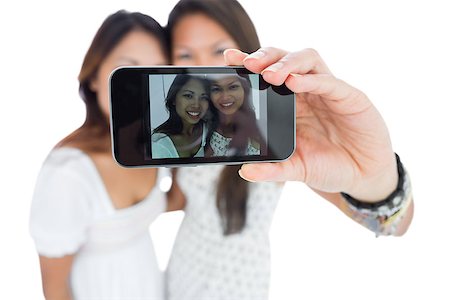 simsearch:400-06889355,k - Two smiling asian sisters taking a self portrait using a smartphone Stockbilder - Microstock & Abonnement, Bildnummer: 400-07139901