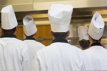 simsearch:400-07140055,k - Five chefs standing in a kitchen turning their back on the camera Stock Photo - Budget Royalty-Free & Subscription, Code: 400-07139921