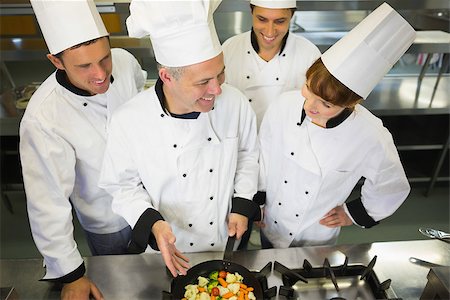 simsearch:400-07141137,k - Experienced head chef showing pan to his colleagues in kitchen Stock Photo - Budget Royalty-Free & Subscription, Code: 400-07139944