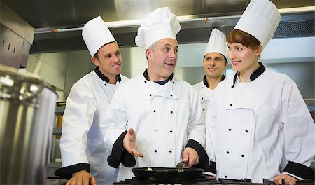 simsearch:400-07140008,k - Experienced head chef explaining food to his colleagues in the kitchen Photographie de stock - Aubaine LD & Abonnement, Code: 400-07139945