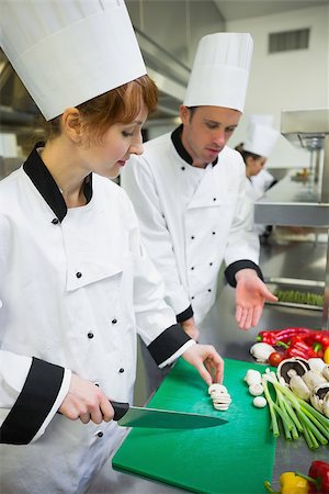 simsearch:400-07140055,k - Chef looking at his colleagues sliced mushrooms in busy kitchen Stock Photo - Budget Royalty-Free & Subscription, Code: 400-07139961