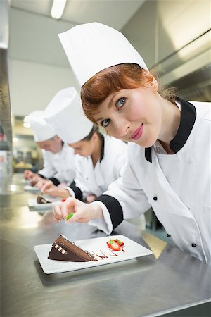 restaurant work teenager - Happy chef garnishing dessert plate standing in a kitchen Foto de stock - Super Valor sin royalties y Suscripción, Código: 400-07139977