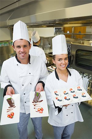 simsearch:400-07140055,k - Two young chefs presenting dessert plates smiling at the camera Stock Photo - Budget Royalty-Free & Subscription, Code: 400-07139994