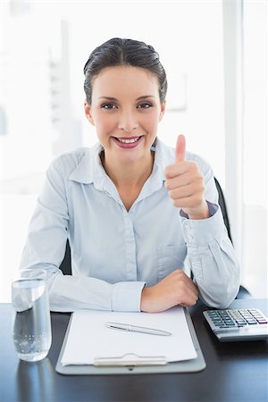 Pleased stylish brunette businesswoman giving thumb up in bright office Stock Photo - Budget Royalty-Free & Subscription, Code: 400-07130906