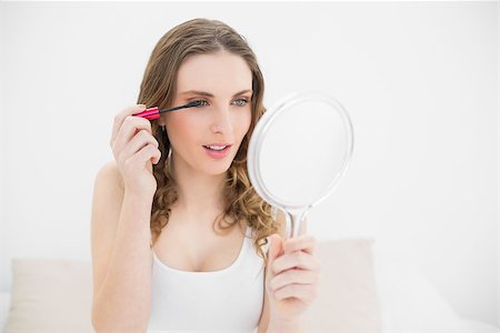 simsearch:693-06323965,k - Pretty woman using mascara in using a mirror Stock Photo - Budget Royalty-Free & Subscription, Code: 400-07131122