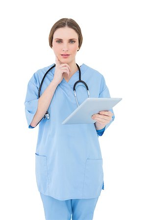 Thinking female doctor holding a tablet and looking into the camera on white background Stock Photo - Budget Royalty-Free & Subscription, Code: 400-07131165
