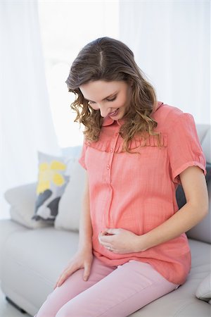 pregnant teen girl - Cheerful pregnant woman sitting in the living room on a couch at home Stock Photo - Budget Royalty-Free & Subscription, Code: 400-07131320