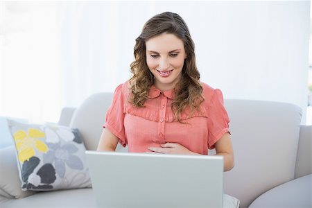 pregnant teen girl - Content pregnant woman using her notebook sitting on couch in the living room at home Stock Photo - Budget Royalty-Free & Subscription, Code: 400-07131333