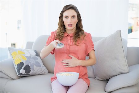 pregnant surprise - Astonished pregnant woman sitting in living room watching television at home Stock Photo - Budget Royalty-Free & Subscription, Code: 400-07131343