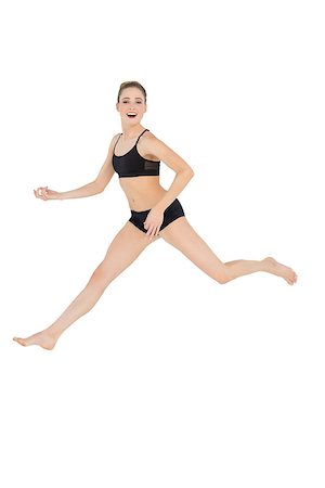 simsearch:400-07138263,k - Happy slim model jumping in the air on white background Stock Photo - Budget Royalty-Free & Subscription, Code: 400-07132532
