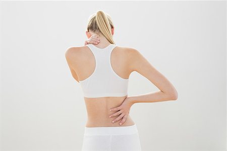 simsearch:400-07138263,k - Slender sporty woman touching her injured nape wearing sportswear Stock Photo - Budget Royalty-Free & Subscription, Code: 400-07132800