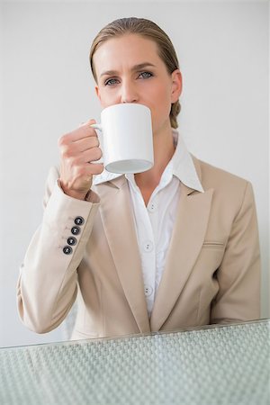 Frowning stylish businesswoman holding mug in bright office Photographie de stock - Aubaine LD & Abonnement, Code: 400-07133294