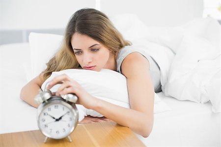 simsearch:614-02613098,k - Gorgeous tired woman lying on her bed turning off the alarm clock Stockbilder - Microstock & Abonnement, Bildnummer: 400-07133546