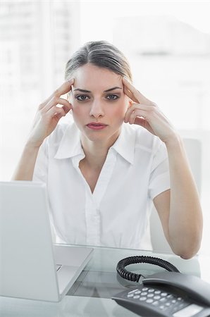 phone with pain - Businesswoman having a headache at work sitting at her desk Stock Photo - Budget Royalty-Free & Subscription, Code: 400-07133675