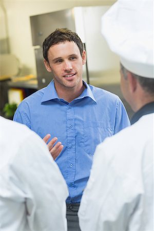 simsearch:400-07140055,k - Young manager talking to the staff standing in a kitchen Stock Photo - Budget Royalty-Free & Subscription, Code: 400-07140036
