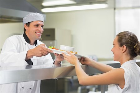 simsearch:400-07140055,k - Young happy chef handing a plate to the waitress smiling at her Stock Photo - Budget Royalty-Free & Subscription, Code: 400-07140038