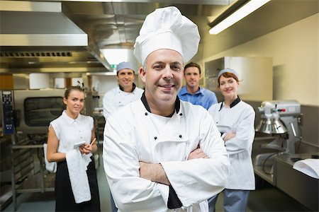 simsearch:400-07140055,k - Head chef posing with team behind him in a professional kitchen Stock Photo - Budget Royalty-Free & Subscription, Code: 400-07140033