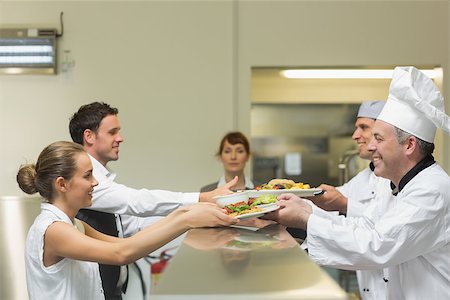 simsearch:400-07140055,k - Two cooks handing plates to servers being watched by the female manager Stock Photo - Budget Royalty-Free & Subscription, Code: 400-07140044