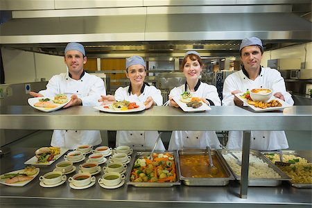 simsearch:400-07140055,k - Four young chefs showing plates standing in a modern kitchen Stock Photo - Budget Royalty-Free & Subscription, Code: 400-07140049