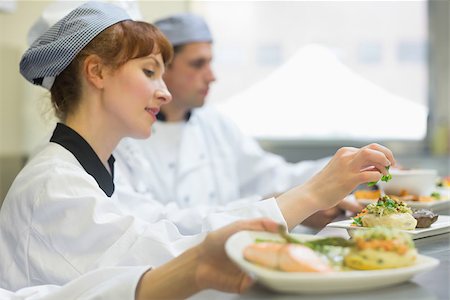 simsearch:400-07140055,k - Young female chef preparing a plate in a professional kitchen Stock Photo - Budget Royalty-Free & Subscription, Code: 400-07140057
