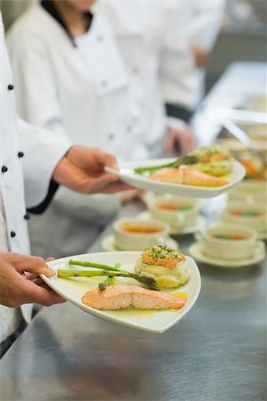 simsearch:400-07140055,k - Chef holding salmon dish standing next to his colleagues Stock Photo - Budget Royalty-Free & Subscription, Code: 400-07140051