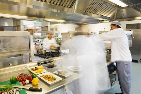 restaurant work teenager - Chefs busy at work in a busy kitchen Photographie de stock - Aubaine LD & Abonnement, Code: 400-07140066