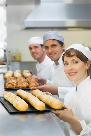 Three young bakers holding baking trays with food on them Stock Photo - Budget Royalty-Free & Subscription, Code: 400-07140104