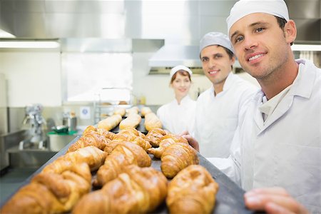 simsearch:400-07140099,k - Three young bakers posing in a bakery smiling at the camera Foto de stock - Royalty-Free Super Valor e Assinatura, Número: 400-07140106