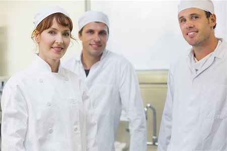 Three bakers posing in a kitchen smiling at the camera Stock Photo - Budget Royalty-Free & Subscription, Code: 400-07140117