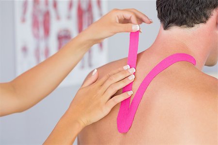 physical therapy shoulder - Physiotherapist putting on pink kinesio tape on male patients neck in bright office Stock Photo - Budget Royalty-Free & Subscription, Code: 400-07140297